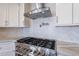 Close up view of a stainless steel stove and oven with a stainless steel exhaust fan and custom backsplash at 18430 E Ashridge Dr, Queen Creek, AZ 85142