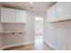 Laundry room with built-in cabinets, workspace, and access to the primary bathroom at 18430 E Ashridge Dr, Queen Creek, AZ 85142