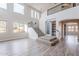 Bright living room with large windows, staircase, and wood-look flooring at 18430 E Ashridge Dr, Queen Creek, AZ 85142