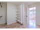 Bright walk-in closet with custom shelving and tile flooring near the primary bathroom at 18430 E Ashridge Dr, Queen Creek, AZ 85142