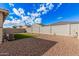 Gravel backyard with a square of artificial grass and block wall fence at 18434 W Chama Dr, Surprise, AZ 85387