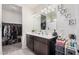 Bathroom with dual sink vanity, neutral walls, and a large walk-in closet at 18434 W Chama Dr, Surprise, AZ 85387