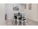 A dining area features a dark wood table, white chairs, tile flooring, and neutral wall colors at 18434 W Chama Dr, Surprise, AZ 85387