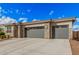 Charming home exterior with a stone facade, neutral color palette, and a spacious three-car garage at 18434 W Chama Dr, Surprise, AZ 85387