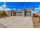 Charming home exterior with a stone facade, neutral color palette, and a spacious three-car garage at 18434 W Chama Dr, Surprise, AZ 85387