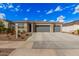 Charming home exterior with a stone facade, neutral color palette, and a spacious three-car garage at 18434 W Chama Dr, Surprise, AZ 85387