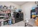 A laundry room features a washer and dryer, shelving, and storage space at 18434 W Chama Dr, Surprise, AZ 85387