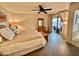 A bright main bedroom featuring wood-look floors, ceiling fan, and sliding glass door to outdoor patio at 18753 E Chinle Dr, Rio Verde, AZ 85263