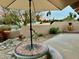 This outdoor patio features a unique stone table with benches and an umbrella, perfect for enjoying the desert landscape at 18753 E Chinle Dr, Rio Verde, AZ 85263