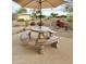 This outdoor patio features a unique stone table with benches and an umbrella, perfect for enjoying the surrounding desert landscape at 18753 E Chinle Dr, Rio Verde, AZ 85263