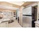 Galley kitchen featuring stainless steel refrigerator and adjacent dining area at 19093 N 97Th Ln, Peoria, AZ 85382