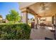 Covered patio with brick pillars provides a view of the manicured backyard and green space at 19093 N 97Th Ln, Peoria, AZ 85382