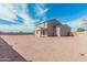 Exterior view of the home showcasing the backyard, covered patio, and block fence at 1997 E Brooklyn Dr, Casa Grande, AZ 85122