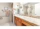 Well-lit bathroom with granite countertop, double mirrors, and a separate glass-enclosed shower at 20603 N Stonegate Dr, Sun City West, AZ 85375