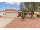 Inviting home with a well-manicured front yard, a two-car garage, and charming desert landscaping at 20603 N Stonegate Dr, Sun City West, AZ 85375