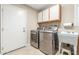 Functional laundry room with modern washer/dryer, storage, and a utility sink at 20603 N Stonegate Dr, Sun City West, AZ 85375