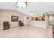 Spacious living room featuring tile floors, vaulted ceilings, and open access to kitchen area at 20603 N Stonegate Dr, Sun City West, AZ 85375