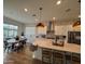 Bright kitchen featuring white cabinets, stainless steel appliances, a large island, and an adjacent dining area at 22703 E Alyssa Rd, Queen Creek, AZ 85142