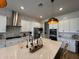 Open kitchen with island featuring a sink, stone backsplash, stainless appliances, and bar stool seating at 22703 E Alyssa Rd, Queen Creek, AZ 85142