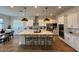 Spacious kitchen featuring an island, white cabinets, stainless steel appliances, and modern pendant lighting at 22703 E Alyssa Rd, Queen Creek, AZ 85142