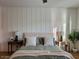 Cozy main bedroom showcasing a paneled accent wall, neutral decor, and soft natural lighting at 22703 E Alyssa Rd, Queen Creek, AZ 85142