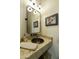 Stylish powder room with a granite countertop, copper sink, decorative mirror and light fixture at 25409 N Ranch Gate Rd, Scottsdale, AZ 85255