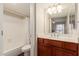 Clean bathroom featuring wood cabinetry, a shower-tub combination, and a decorative mirror at 2625 E Indian School Rd # 240, Phoenix, AZ 85016