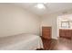 Simple bedroom setup with wood floors, a dresser, and a view of the adjacent bathroom at 2625 E Indian School Rd # 240, Phoenix, AZ 85016