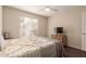 Cozy bedroom features a ceiling fan, window, and light wood dresser with TV at 2625 E Indian School Rd # 240, Phoenix, AZ 85016