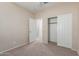 This bedroom features neutral walls, carpeted floors, an open closet, and an open doorway at 274 W Kona Dr, Casa Grande, AZ 85122