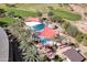 Stunning aerial view of a community pool and golf course, with red sunshades and numerous lounge chairs at 29816 N 129Th Gln, Peoria, AZ 85383