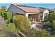 A tranquil backyard featuring a hot tub, covered patio, and lush desert landscaping at 29816 N 129Th Gln, Peoria, AZ 85383