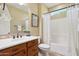 This simple bathroom features a single sink, wood cabinetry, a framed mirror, and a shower with a curtain at 29816 N 129Th Gln, Peoria, AZ 85383