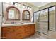 This bathroom features double sinks, wood cabinetry, a tile backsplash, and a glass shower at 29816 N 129Th Gln, Peoria, AZ 85383