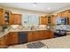 This spacious kitchen features wood cabinetry, granite countertops, a black range, and stainless steel appliances at 29816 N 129Th Gln, Peoria, AZ 85383