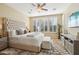 This beautiful bedroom features a tufted headboard, neutral tones, bright windows and updated furnishings at 29816 N 129Th Gln, Peoria, AZ 85383