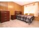 Comfortable bedroom with wood paneling, a queen bed, and a chest of drawers at 303 S Recker Rd # 152, Mesa, AZ 85206