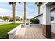 Home's landscaped front yard with lush green lawn, mature palm trees and brick-paved patio at 4241 E Montecito Ave, Phoenix, AZ 85018