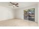 This bedroom is light and bright, with tile floors, a ceiling fan, and access to the backyard at 4436 W Morrow Dr, Glendale, AZ 85308