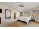 Bright main bedroom suite featuring a ceiling fan, neutral tones, and an en-suite bathroom at 4514 E Mazatzal Dr, Cave Creek, AZ 85331