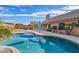 Beautiful backyard pool reflecting the sky, surrounded by palm trees and an outdoor kitchen at 4514 E Mazatzal Dr, Cave Creek, AZ 85331