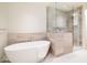 A luxurious bathroom featuring a standalone tub and a glass-enclosed shower with modern tile finishes at 5000 N Camelback Ridge Dr # 304, Scottsdale, AZ 85251