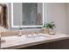 Bathroom vanity features a marble countertop, a sleek sink and faucet, and an LED-backlit mirror at 5000 N Camelback Ridge Dr # 304, Scottsdale, AZ 85251