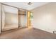 This bedroom features carpet, mirrored closet doors, and an open door to the laundry area at 535 S Alma School Rd # 60, Mesa, AZ 85210