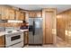 A kitchen featuring wood cabinets, stainless steel refrigerator and a white range at 535 S Alma School Rd # 60, Mesa, AZ 85210