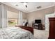 Well-lit bedroom with a ceiling fan, carpeted floors, and a view of the backyard at 6442 W Cavedale Dr, Phoenix, AZ 85083