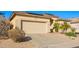 Single-story home with a neutral exterior, two-car garage, desert landscaping, and solar panels at 6442 W Cavedale Dr, Phoenix, AZ 85083