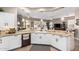 Bright kitchen featuring white cabinets and tile backsplash with a view into the main living area at 6442 W Cavedale Dr, Phoenix, AZ 85083