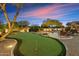 Beautiful backyard with a pristine putting green, outdoor lounge, and a rock waterfall pool at 6626 E Oberlin Way, Scottsdale, AZ 85266