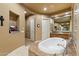 Bright bathroom with a large marble tub, and doorways leading to other rooms at 6626 E Oberlin Way, Scottsdale, AZ 85266